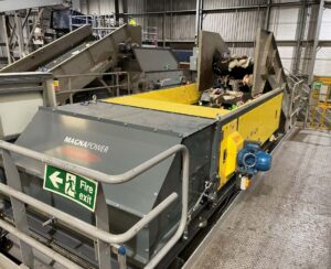 Eddy current separator extracting non-ferrous metals from eddy current waste stream with advanced magnetic separator setup for recycling and material recovery.