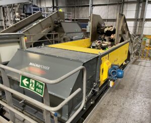 Eddy current separator extracting non-ferrous metals from eddy current waste stream with advanced magnetic separator setup for recycling and material recovery.