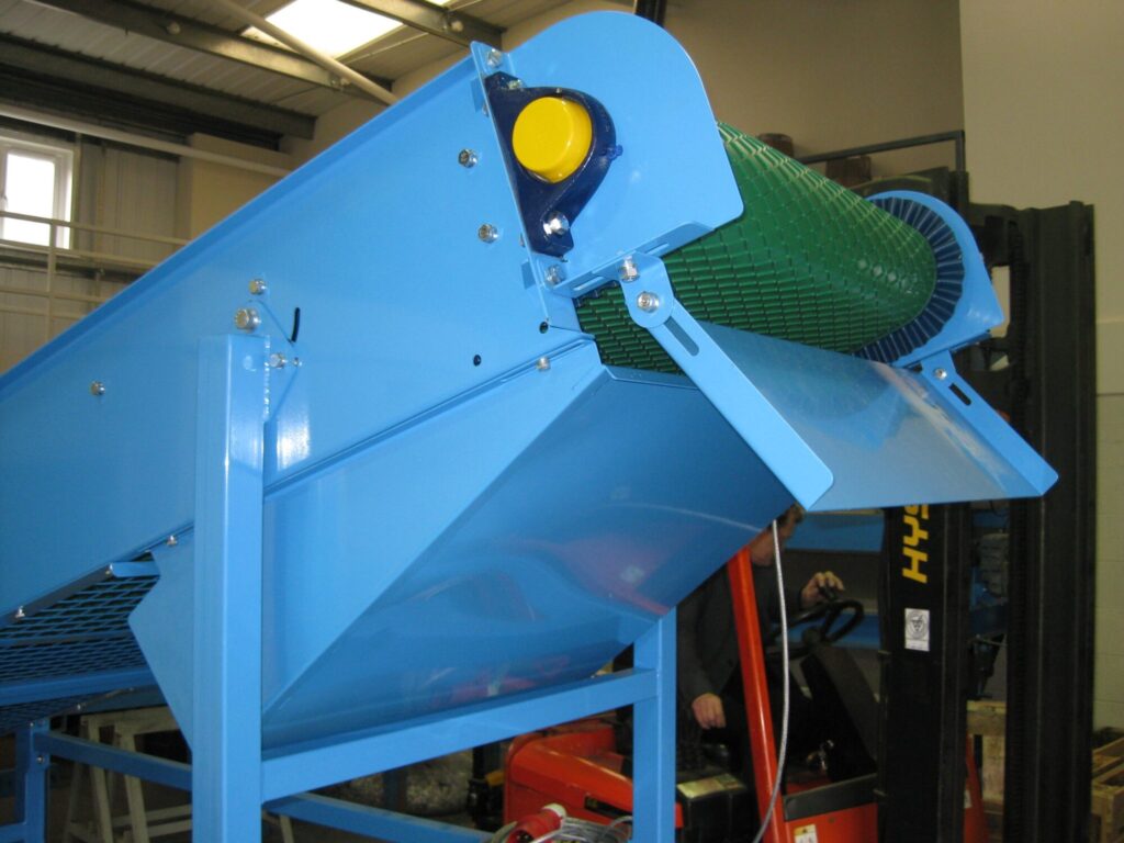 Image of a Magnapower magnetic head pulley installed at the end of a conveyor belt, designed for separating ferrous metals from bulk materials. data-large-image=