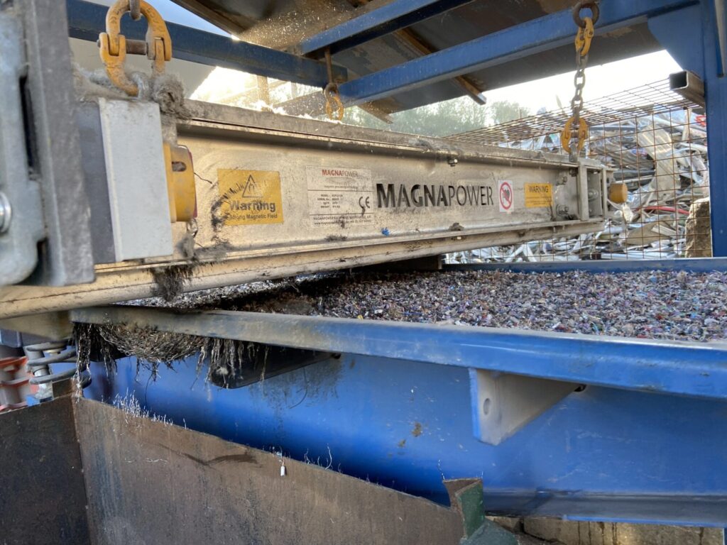 Overband magnetic separator removing ferrous metals from waste stream in a recycling and magnetic separation system. data-large-image=