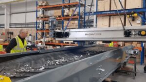 Overband magnetic separator removing ferrous metals from waste stream in a recycling and magnetic separation system.