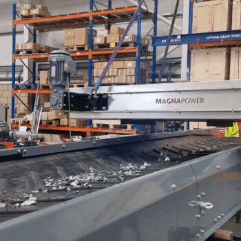 Overband magnetic separator removing ferrous metals from waste stream in a recycling and magnetic separation system.