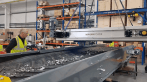 Overband magnetic separator removing ferrous metals from waste stream in a recycling and magnetic separation system.