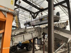 Overband magnet mounted above a conveyor at AEB Amsterdam, extracting metal nitrous oxide canisters from the waste stream.
